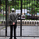 A person stands behind the closed gate of a housing complex in Shanghai on April 27, 2022, as the COVID-19 lockdown continues in the Chinese city for a month.